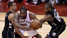 Kawhi Leonard z Toronta se probíjí obranou Milwaukee mezi Georgem Hillem a...