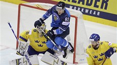 Finský hokejista Harri Pesonen uskakuje ped pukem, v brán je véd Henrik...