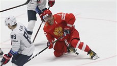 Ruský útoník Alexandr Ovekin padá na led v souboji s americkým protivníkem.