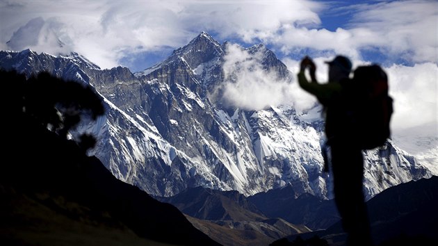 Turista fot himaljskou horu Nuptse nedaleko nejvy hory svta Mt. Everestu (vlevo v mracch).
