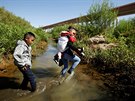 Migranti z Guatemaly nelegáln pekraují hranice z Mexika do USA. (6. ervna...