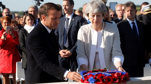 Britsk premirka Theresa Mayov a francouzsk prezident Emanuel Macron poloili zkladn kmen budoucho britskho pamtnku ve Ver-sur-Mer. (6. ervna 2019)