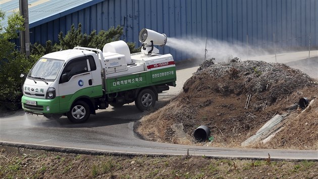 Veterináři rozprašují na prasečí farmě v Jižní Koreji dezinfekci v souvislosti s vypuknutím afrického moru prasat. (3. června 2019)
