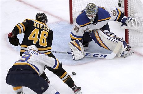 Jordan Binnington, glman St. Louis, zasahuje proti bostonskmu Davidu Krejmu.