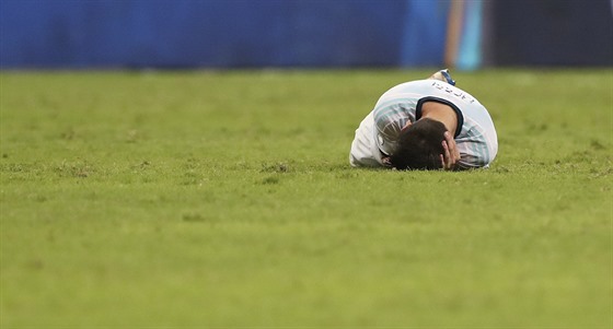 Argentinský kapitán Lionel Messi leí na trávníku.