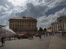 Turisté i Praané se chladí díky kropícímu vozu na Hradanském námstí v Praze...