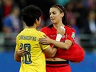 Americká fotbalistka Alex Morganová (vpravo) utuje thajskou gólmanku Sukanyu...