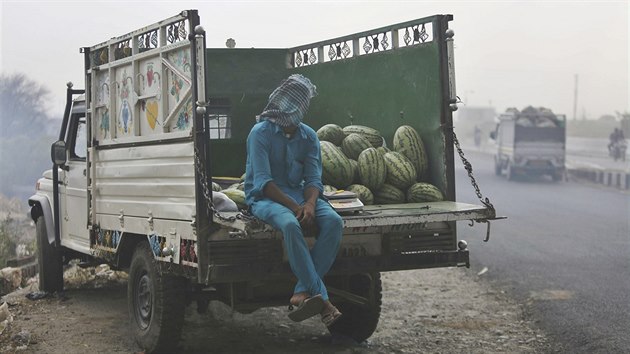 Prodejce meloun si zakrv hlavu ped prachovou bou, kter se zvedla ve vyschlm okol msta Damm (17. erven 2019)