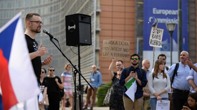 Asi dvě stovky převážně českých občanů protestovaly v Bruselu u budovy Evropské komise proti ohrožení vlády práva v ČR a českému premiéru Andreji Babišovi. Vlevo hovoří europoslanec za Piráty Mikuláš Peksa. (18. června 2019)
