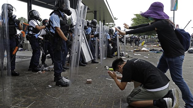 Demonstranti tv v tv policistm bhem protest v Hongkongu.