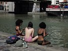 Francouzské dívky se opalují u vodního kanálu Ourcq v Paříži. (28. června 2019)