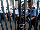 Policisté zamykají bránu policejního sídla poté, co se demonstranti pokusili...