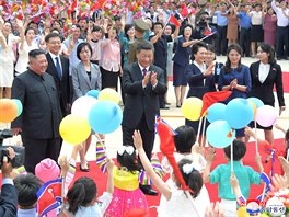 Severokorejské děti vítají vůdce KLDR Kim Čong-una (vlevo) a čínského...