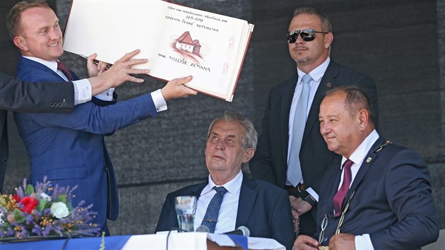 Prezident Milo Zeman se v Bystici nad Perntejnem podepsal do pamtn knihy, kterou mu podal hradn protokol Vladimr Kruli. Starostovi Karlu Paiskovi (vpravo) Zeman vyetl ztrtov Eden, naopak ho pochvlil, jak dlouho u stoj v ele msta.