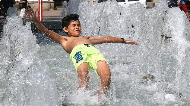 Chlapec se chladí ve fontáně na Lidickém náměstí v Ústí nad Labem. (26. června 2019)