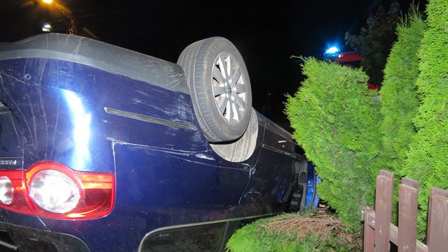 Snmky z nehody v Bludov na umpersku, kdy opil idi nad rnem smykem prorazil plot u rodinnho domu a auto otoil na stechu. (21. ervna 2019)