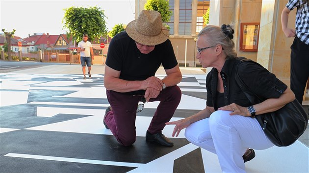 Plocha ped vstupem do lounskho divadla se promnila v uniktn umleck dlo. Piazzetta m podobu ernobl kompozice, kterou na pelomu let 1962 a 1963 vytvoil svtov uznvan mal a lounsk rodk Zdenk Skora na protiporn oponu tho divadla. Na snmku je Skorova manelka Lenka a architekt Josef Pleskot, kter penesl motiv opony na zem.