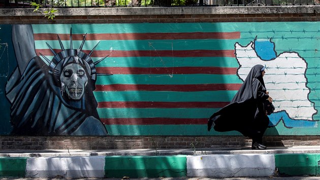 Projevy rnsk averze skoro na kadm kroku. ena jde v Tehernu kolem zdi s grafiti naznaujcm, e se belsk USA sna zotroit rn. (25. ervna 2019)