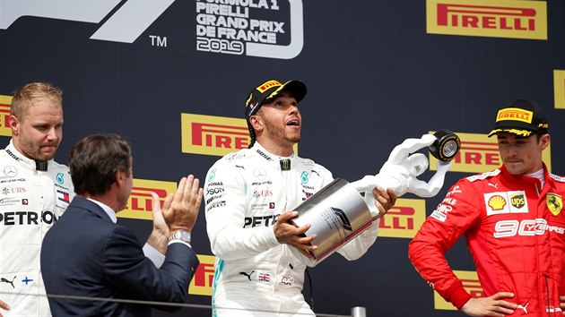 Lewis Hamilton (uprosted) se raduje na stupnch vtz z triumfu ve Velk cen Francie F1. Vlevo druh Valtteri Bottas, vpravo tet Charles Leclerc.