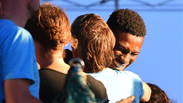 Jeden z migrant na lodi Sea-Watch 3 se objm s posdkou pot, co lo pistla v italskm pstavu na ostrov Lampedusa. (29. ervna 2019)