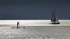 Muž stojí na paddle boardu nedaleko lodi na německém jezeře Ammersee. (26....