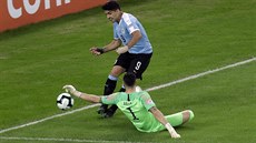 Chilský branká Gabriel Arias vyráí stelu uruguayského útoníka Luis Suáreze,...