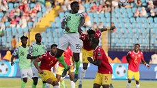 Nigerijský fotbalista Kenneth Omeruo (ve výskoku) stílí gól v zápase s Guineou.