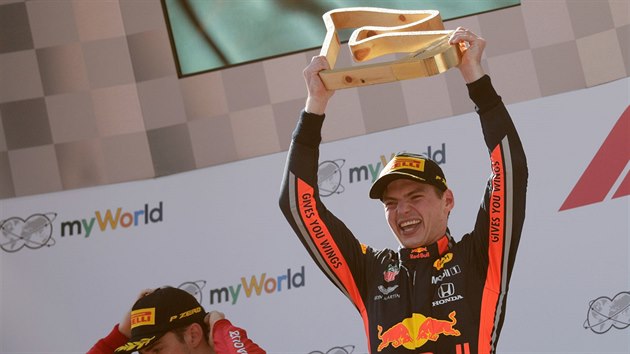 Max Verstappen s trofej pro vtze Velk ceny Rakouska, vlevo je zklaman Charles Leclerc, kter dojel druh.