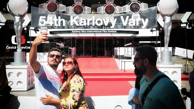 Festivaloví návštěvníci si dělají selfie u červeného koberce před hotelem Thermal.