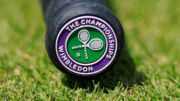 Rukoje tenisov rakety s logem na trv ve Wimbledonu.