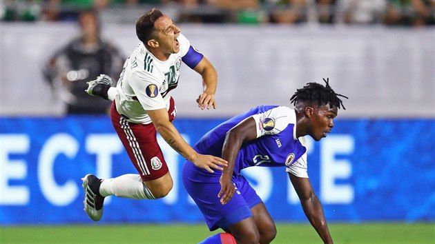 Andres Guardado (vlevo) z Mexika pad po stetu s Bryanem Alceusem z Haiti.