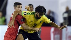 Americký fotbalista Christian Pulisic (vlevo) napadá Michaela Hectora z Jamajky.