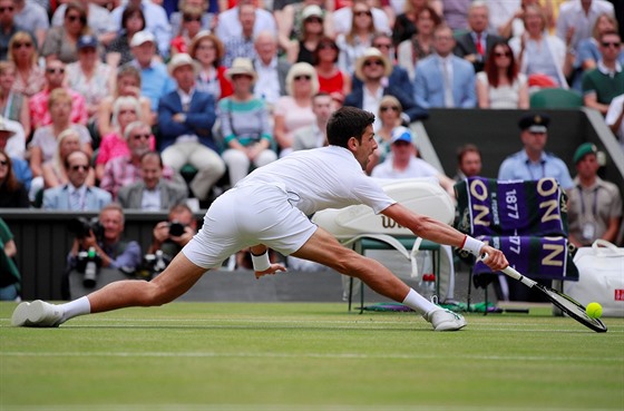 Srb Novak Djokovi se natahuje po balonu bhem finále Wimbledonu.