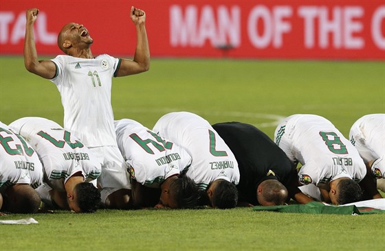 Alírtí fotbalisté se modlí po triumfu na mistrovství Afriky.