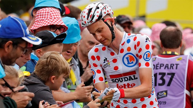 Tim Wellens se v dresu krle hor podepisuje fanoukm na Tour de France.