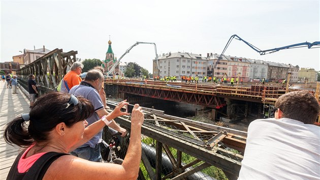 Stavaři betonují nosnou konstrukci mostu na Komenského ulici v Olomouci. Most musí být vybetonovaný bez přerušení najednou, domíchávače vozily beton ze dvou betonáren. Konstrukce spolkne přibližně 1400 kubíků betonu. Stavba nového mostu je součástí budování protipovodňové ochrany v Olomouci. (19. července 2019)