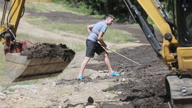 Pracovnci zarovnvaj ve Ski&Bike arelu pik na umav jeden zsek sjezdovky U zalomenho. Na svah navej speciln kompost pochzejc zluk NP umava. (16. 7. 2019)