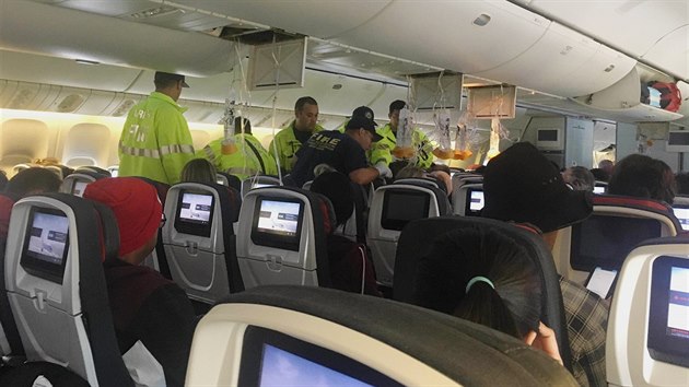 Zdravotnci se staraj o jednoho z cestujcch letu spolenosti Air Canada z Vancouveru do Sydney, kter musel nouzov pistt na letiti v Honolulu (11. ervence 2019).