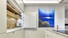 Kuchyň díky bílé barvě a světlému dřevu na podlaze navozuje dojem vzdušnosti a...