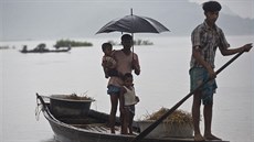 Lidé z vesnice Katahguri plují po rozvodnné ece Brahmaputra na jihu msta...