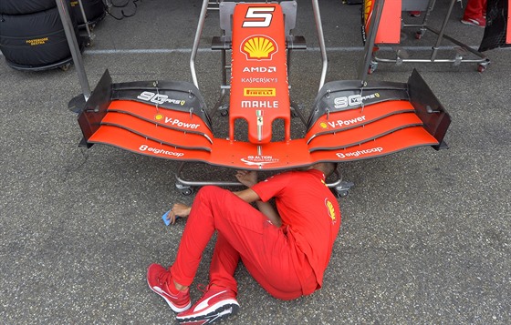 Jeden z mechanik stáje Ferrari nastavuje vz Sebastiana Vettela.