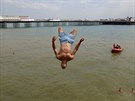 Mladý mu skáe po hlav do vody v anglickém Brightonu (25. 7. 2019).