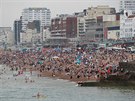 Lidé se bhem horkého odpoledne koupají na plái v anglickém Brightonu (25. 7....