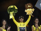 Vítz Tour de France Egan Bernal z Ineosu slaví na pódiu s kyticí a plyákem.
