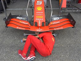 Jeden z mechanik stáje Ferrari nastavuje vz Sebastiana Vettela.