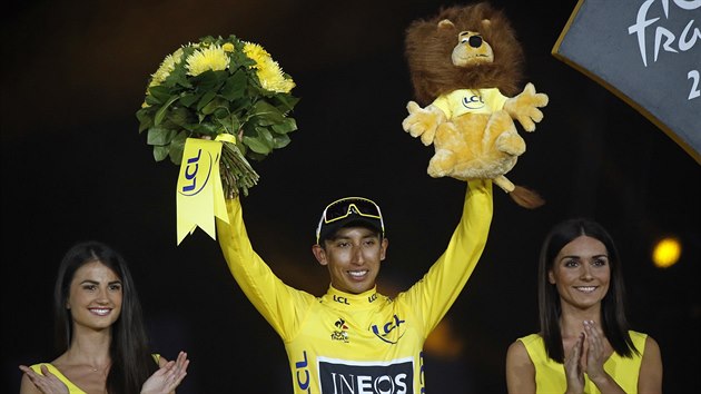 Vtz Tour de France Egan Bernal z Ineosu slav na pdiu s kytic a plykem.