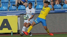 Ostravský kapitán Milan Baro� centruje p�es Patrika �itného z Teplic (vpravo).