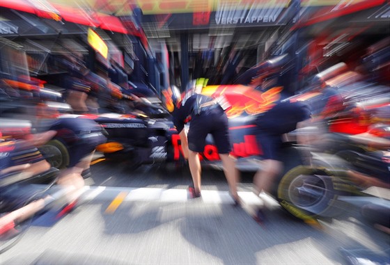 PÍLI RYCHLÍ I NA FOTOGRAFA. Mechanici stáje Red Bull pi práci.