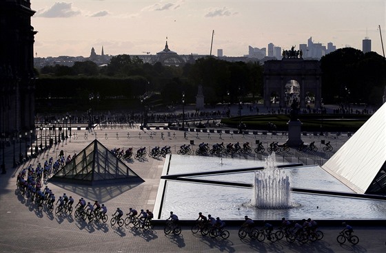 TRADINÍ ZÁVR. Peloton cyklist projídí nádvoím muzea Louvre v Paíi bhem...