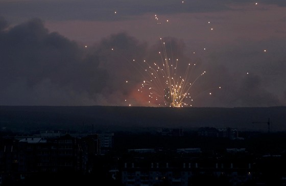 Plameny a kou stoupají z místa výbuch v muniním skladu poblí ruského msta...